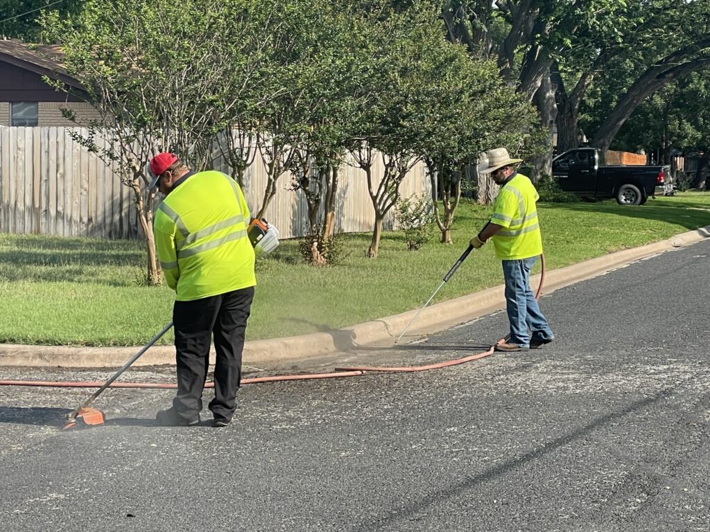 Empleados de Obras Públicas preparando una calle para mantenimiento