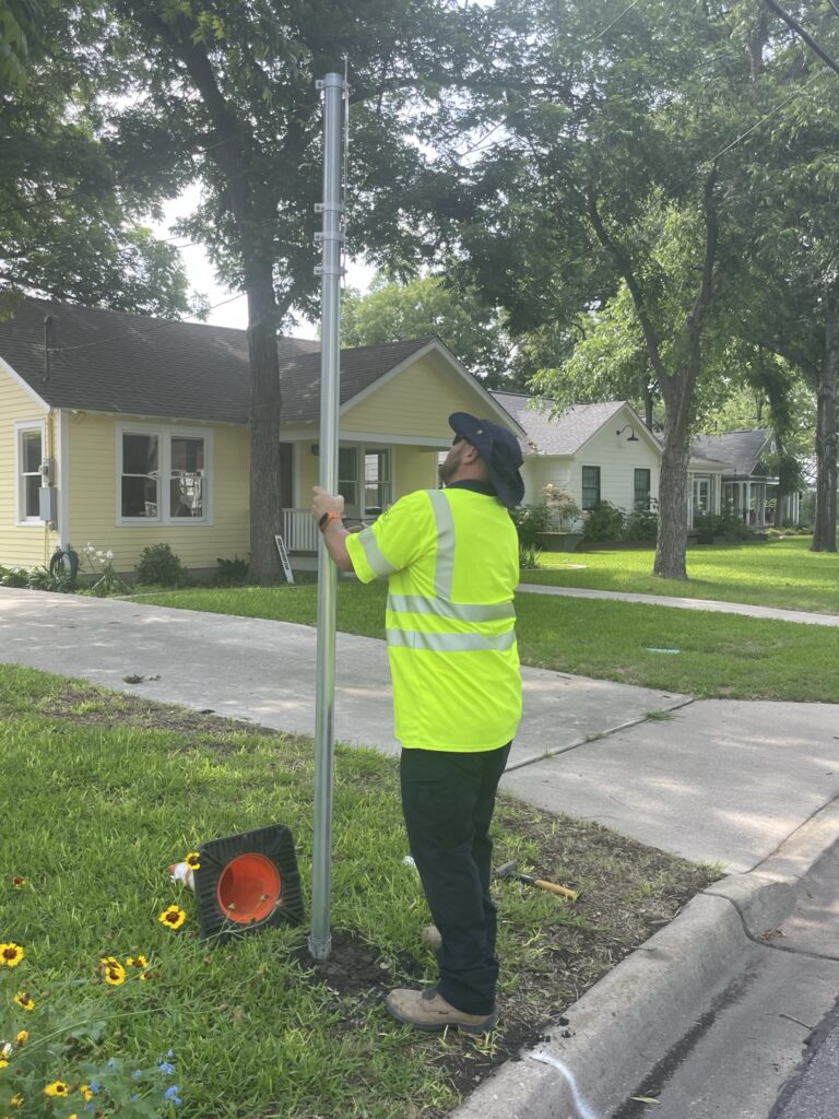 A public works employee installing a new no-parking sign in Old Town.
